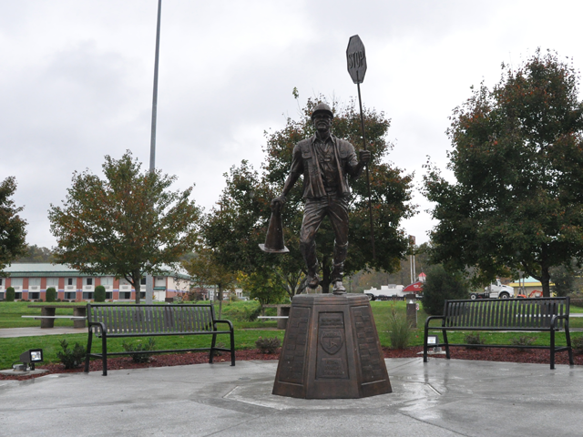 The WVDOT Fallen Worker Memorial bronze statue, depicting a highway worker holding a stop sign and a traffic cone.