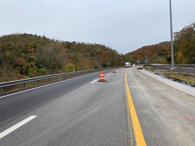 A newly paved highway shoulder with orange and white construction barrels on the I-70 Forward project in Wheeling.